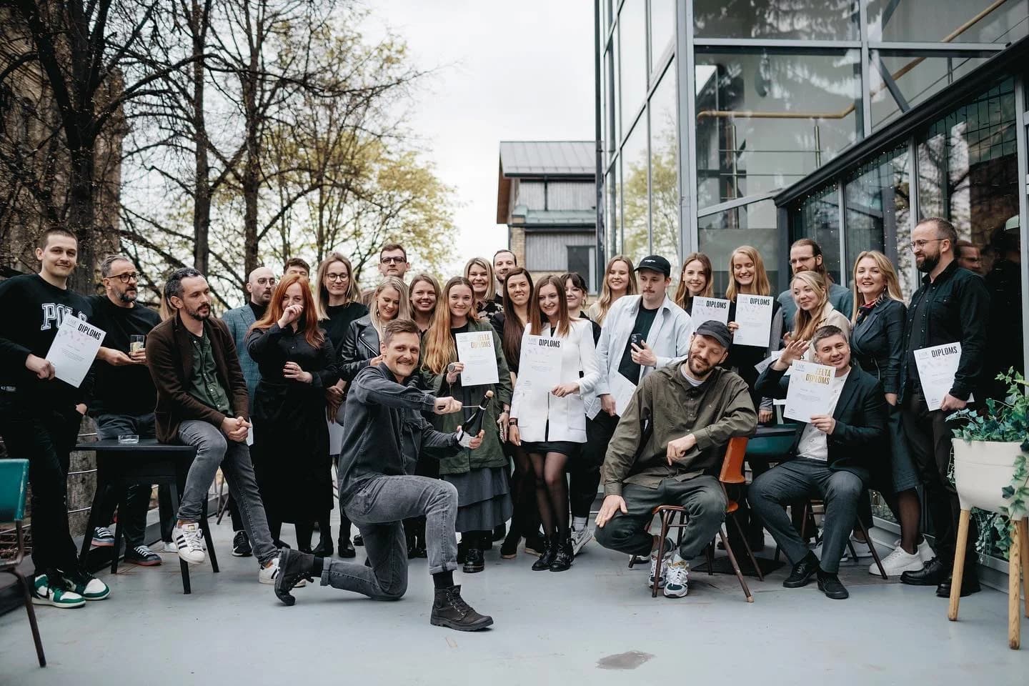 A school graduation group holding their diplomas.