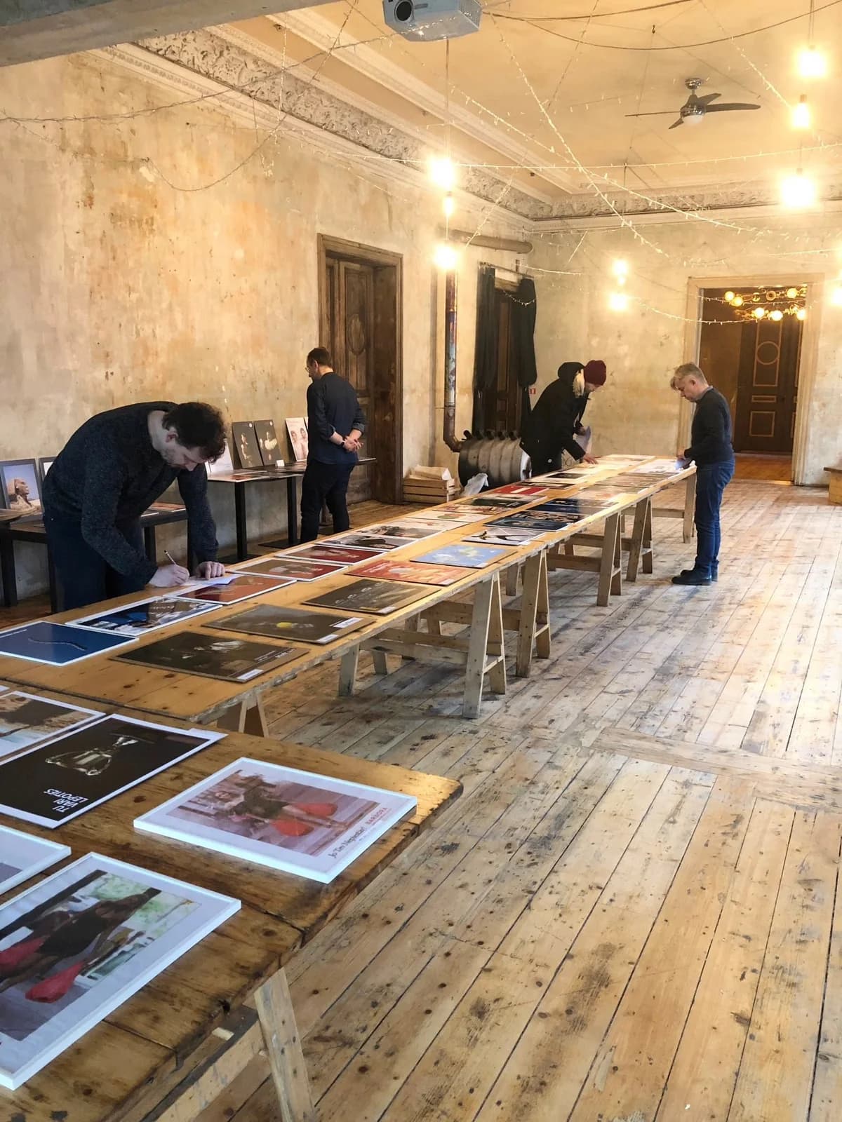 People reviewing posters laid out along long tables.